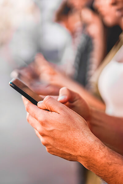 Personne utilisant un smartphone en mobilité, illustrant l’accès aux services numériques, à internet mobile et à la connectivité au quotidien